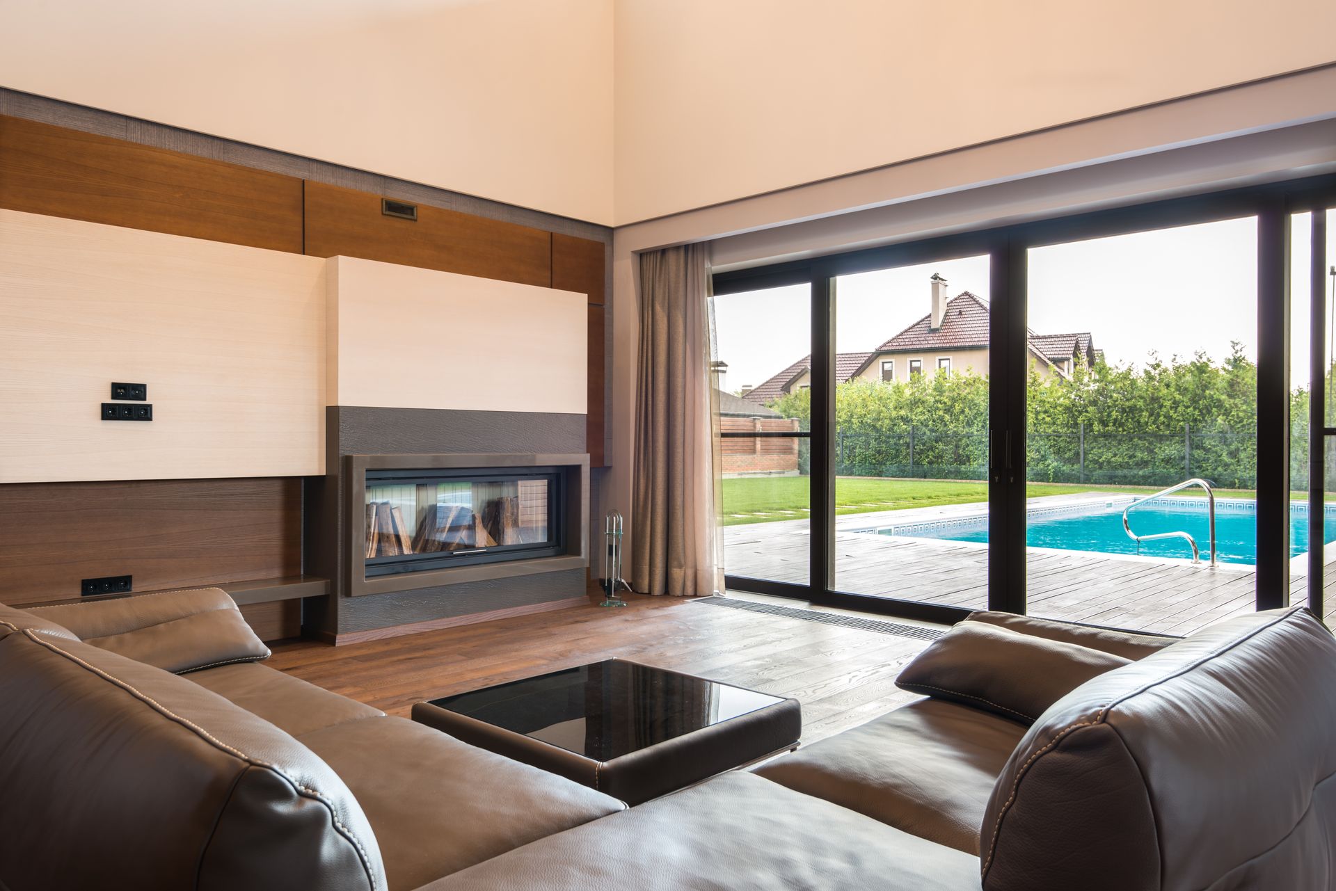 Salon contemporain ouvert sur une baie coulissante aluminium donnant sur la piscine