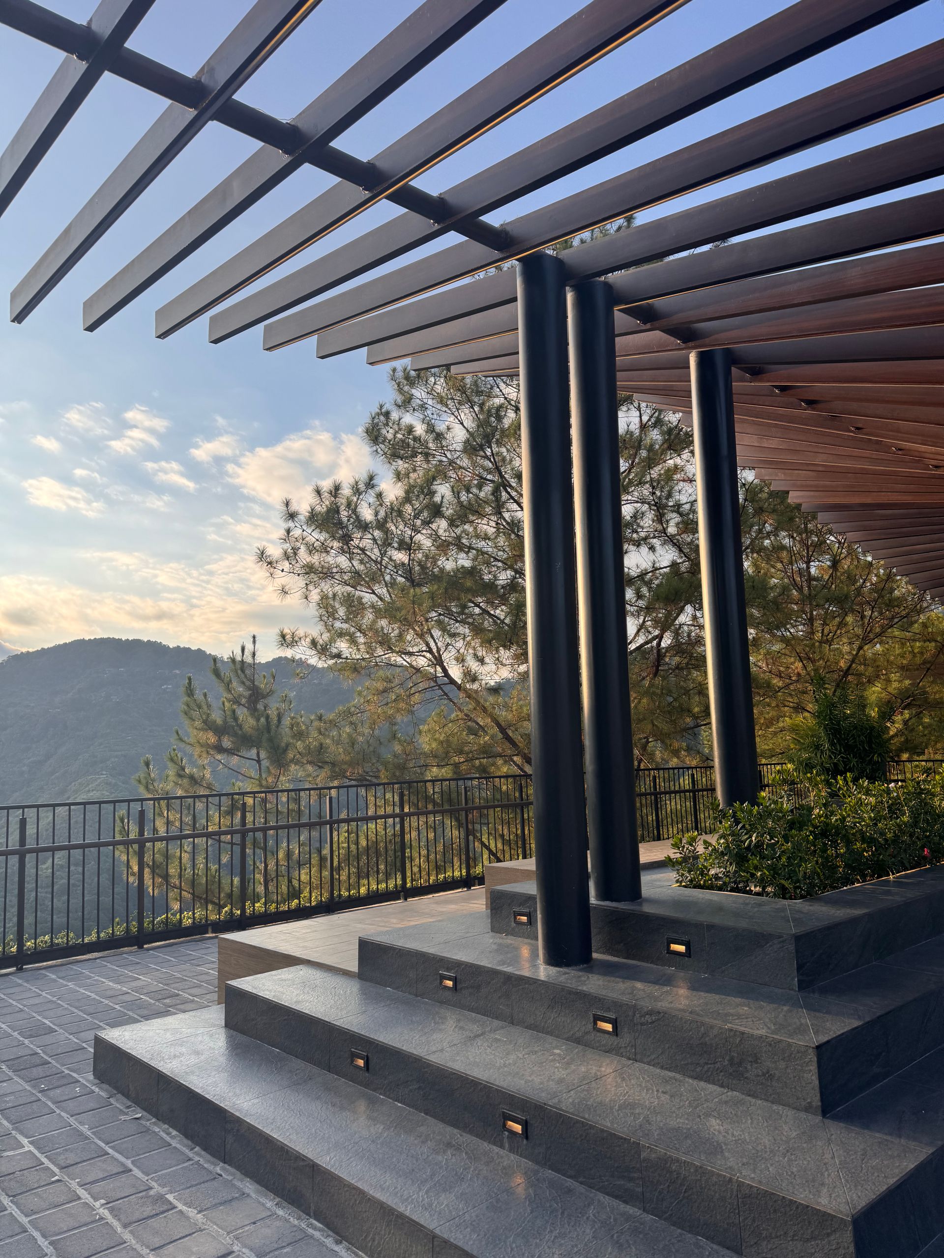 Pergola aluminium noire face à un panorama de montagnes